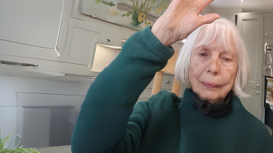 An older woman raising her hand