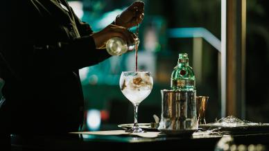 A bartender stirring a glass of gin
