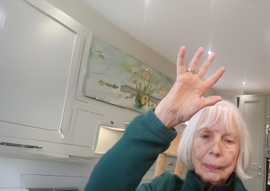 an older woman raising her hand